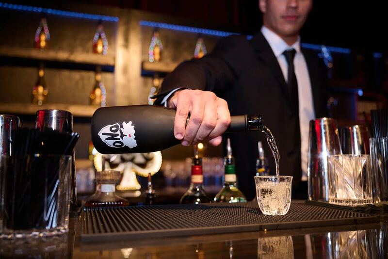 A bartender pouring a cocktail at the Club SI bar